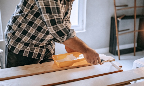 Man painting wood white