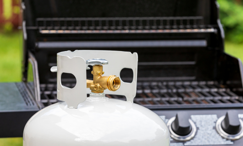 a propane tank sitting in front of an open grill